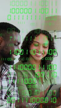Vertical video: Woman tapping tablet man pointing both viewing tech content green binary overlay