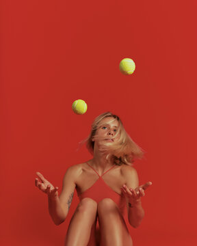 Sporty lady in activewear focused on ball on red