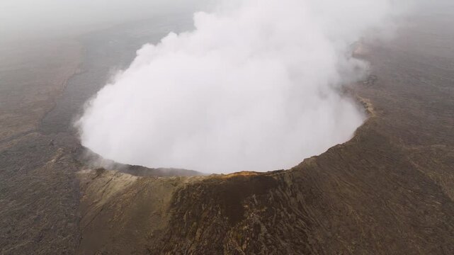 Aerial view of Erta Ale Volcano with a thick plume of white smoke rising from the crater in Danakil Desert, Afar, Ethiopia.