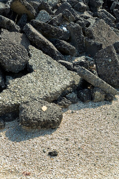Cracked asphalt pieces after demolition of a road surface in a construction site for renovation ready to be recycled