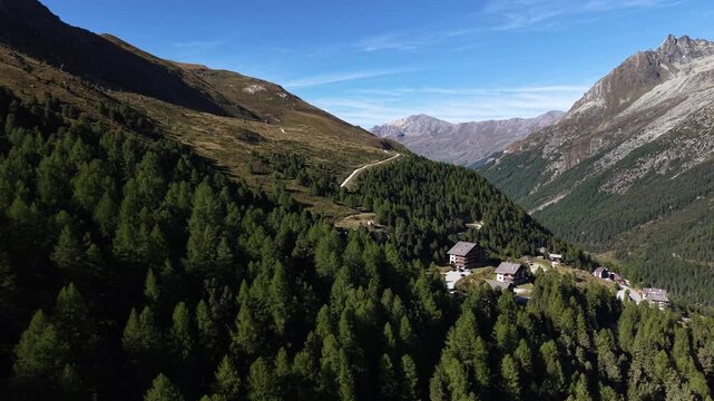 Aerial flyover over the forest near the alpine village of Arolla, Switzerland on a sunny summer day in the Swiss Alps