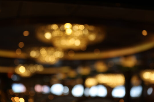 abstract blurred golden chandelier lights with bokeh effect in a luxury ballroom or hotel lobby background