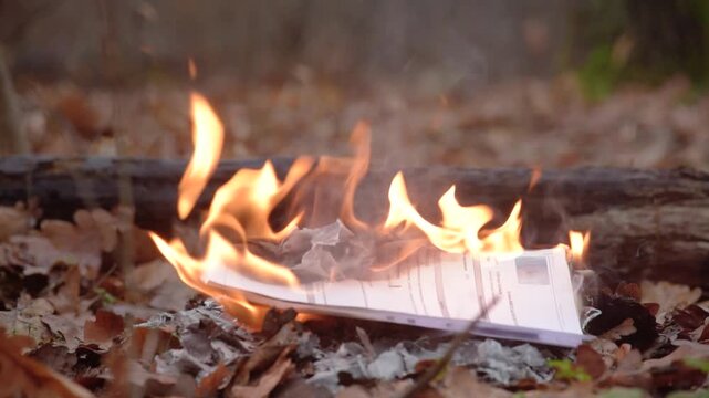 Burning letter during a symbolic moment of letting go Burning stack of old documents on woodland ground as an act of destroying personal memories and secrets