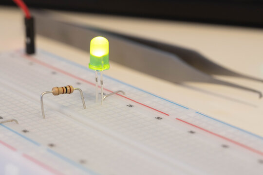 Green LED with resistor on breadboard, simple electronics project