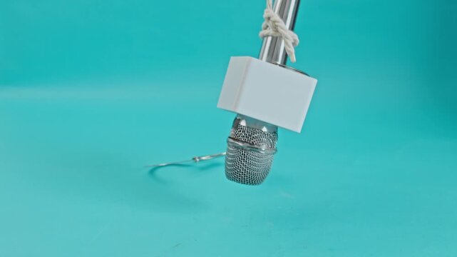 News Microphone Hanging By Rope With Metal Handcuffs Attached For Execution Of Press Freedom And Peril Of Modern Journalism