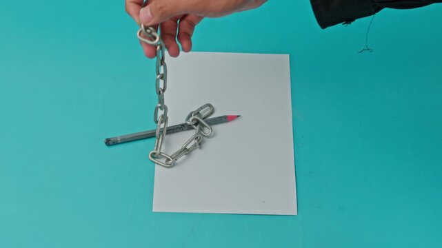 Conceptual Video Of Pencil Being Unchained On Blue Background For Freedom Of Press And Power Of Independent Journalism