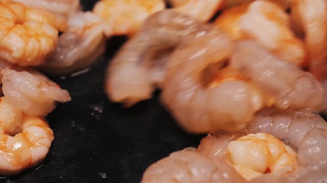 Close-up of shrimp being cooked over low heat in a frying pan. High quality 4k footage
