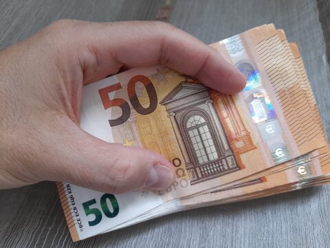 Banconote da 50 euro nelle mani di un uomo - business	