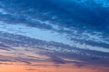 Obraz premium Beautiful evening sky panorama with textured clouds illuminated by colorful sunset gradients and fading daylight