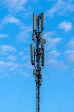 Modern mobile communication mast featuring 5G network antennas and telecom infrastructure under cloudy sky