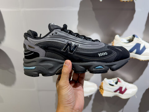 KUALA LUMPUR, MALAYSIA - FEB 02, 2026: Close up of a hand holding a black New Balance 1000 sneaker inside a retail shoe store.