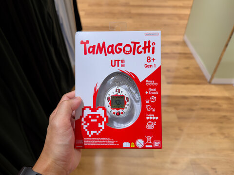 KUALA LUMPUR, MALAYSIA - FEB 02, 2026: Close up of a person holding Tamagotchi x Uniqlo UT Gen 1 digital pet toy box in retail store.
