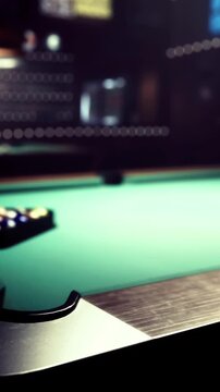 People gather around a green pool table in a bar during the evening. The lights are dim, and the atmosphere is lively as players take turns shooting.