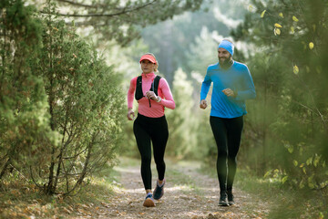Obraz premium Couple Running On Forest Trail Together For Fitness And Outdoor Training In Autumn Morning