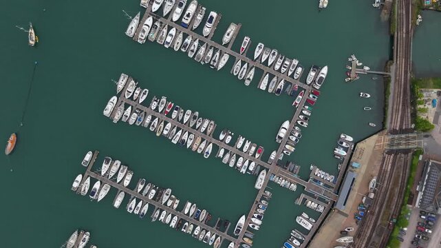 Aerial view of Dartheaven marina with docked yachts at the Dartmouth Harbour which is a natural port located in Dartmouth, Devon, England. Drone POV of Devon Landscape and Town.