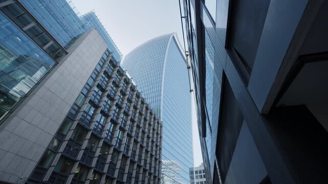 Modern skyscraper rises above city street with glass facades in urban London
