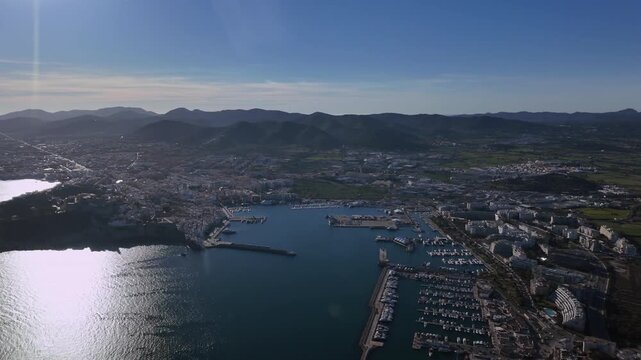 Aerial view of coastal Ibiza city center and harbor captured before sunset from a jet cockpit. Hyperlapse x4.