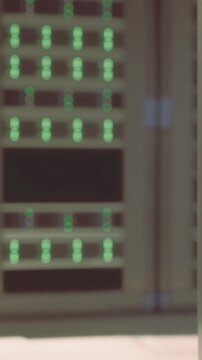 Workers are operating in a data center filled with server racks. The area is busy with people managing equipment and servers during daylight hours. Green lights indicate active devices.