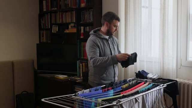 Man folding dry laundry at home