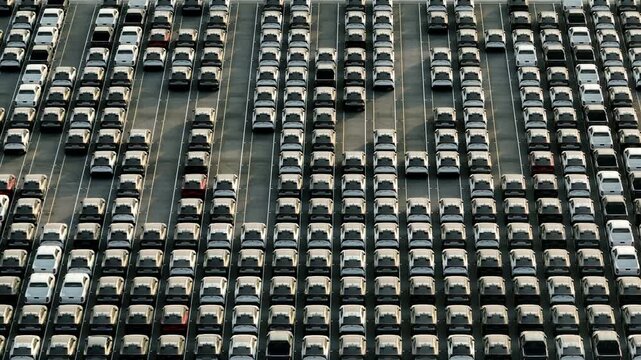 Aerial perspective of newly manufactured cars at a smart automotive plant, representing future transportation networks, clean energy adoption, and digitally connected mobility ecosystems. 4k.
