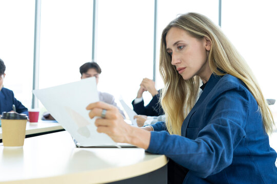 Teamwork. Side view of white woman in a office using laptop during creative meeting and drink coffee. Concept of business, office, finance, open space.