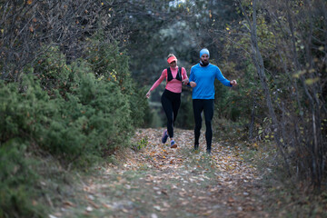 Fototapeta premium Couple Running on Forest Trail Together During Autumn Fitness Jog in Outdoor Workout Clothing