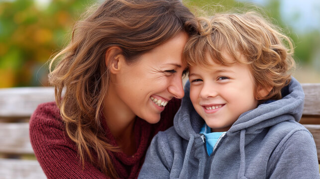 Close-up of a mother and child sharing a joyful moment on a park bench, outdoor family lifestyle concept, simple family happiness, mother child park day, defocused background, with copy