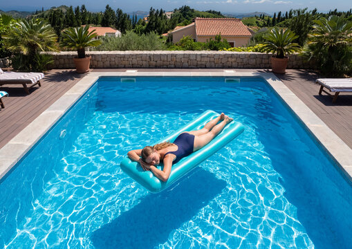 Woman relaxing on float in a swimming pool