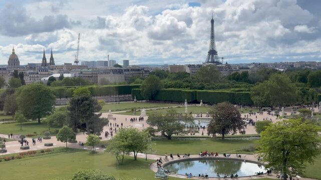 Visitors relaxing around circular pond in Tuileries Garden with Eiffel Tower backdrop