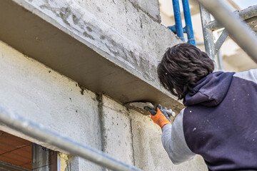 Construction worker applying plaster to concrete wall © Carolina F Varela
