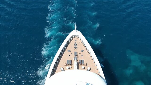 Cruise ship bow sailing through the deep blue ocean water with white foam trail wake