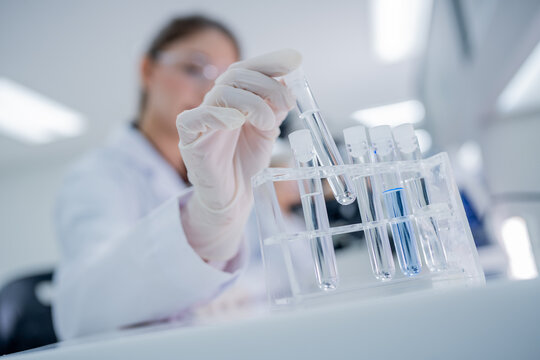 Scientist conducts experiment with test tubes in laboratory during daytime hours