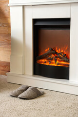 Obraz premium Slippers on soft carpet near fireplace in living room