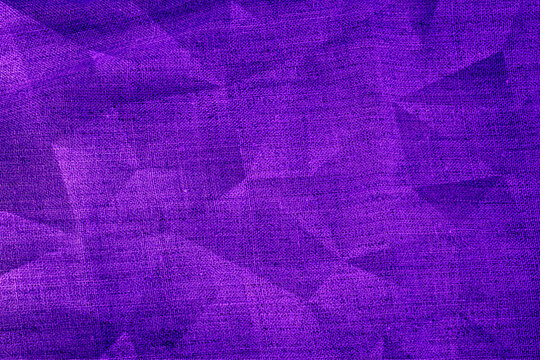 Colorful fabric with a purple pattern shows light and shadow effects in different tones on its surface