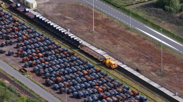 Aerial view of steel coils and shunting locomotive moving on railway tracks