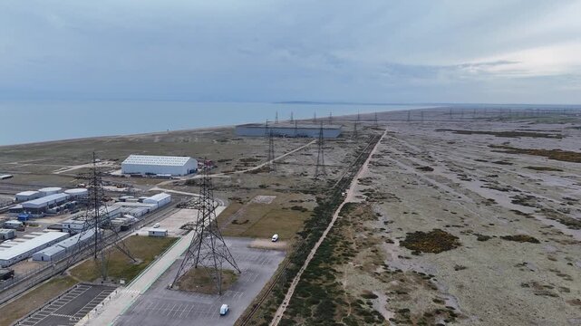 Rows of electricity pylons Dungeness Kent Panning drone aerial desolate beach