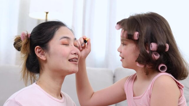 Kids, cosmetic, child, beauty, makeup, A girl with hair curlers applies makeup on her mother's face, sharing fun, care, and joyful connection through an imaginative beauty playtime, bonding family
