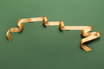 Naklejka premium Beautiful golden ribbon on green background