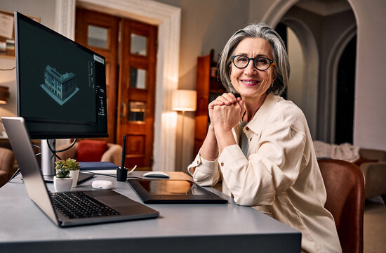 Senior professional woman working at home office desk.