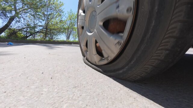 Car driving on a completely flat tire on the asphalt road