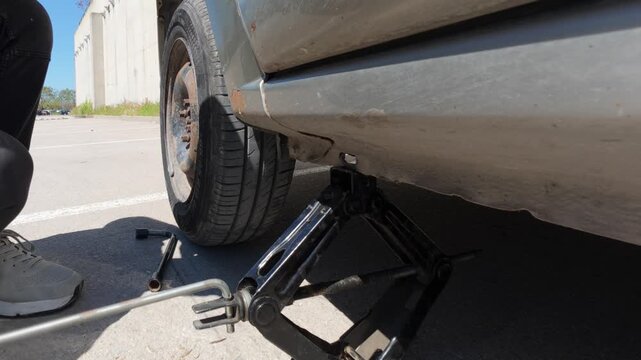 Lowering a car with a scissor jack after spare wheel installation