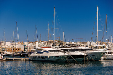 Obraz premium Luxury yachts docked at a pier in a sunny harbor