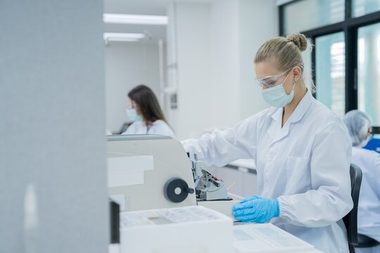 Researchers work in a laboratory on experiments and data analysis in a cleanroom setting during the day