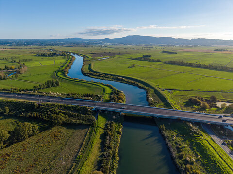 A road bridge crossing the Kaituna River in the rural landscape of the Western Bay of Plenty, New Zealand. Aerial view