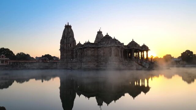 Sunrise at Ancient Hindu Temple with Lake Reflection and Mist