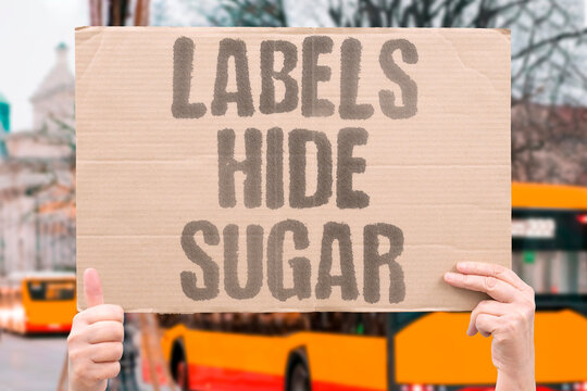 "Labels Hide Sugar" Nutritional labeling systems obscure total sugar content through misleading measurement formats. SUGAR. LABEL. OBSCURE. NUTRITION. MEASURE.