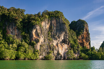 Obraz premium Spectacular golden sunset over the limestone cliffs of Railay West Beach in Krabi, Thailand