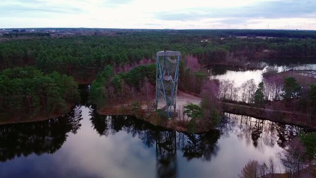 Drone view of the Lommelse Sahara tower and town in the background, scenic landscape view during cloudy sunset.
