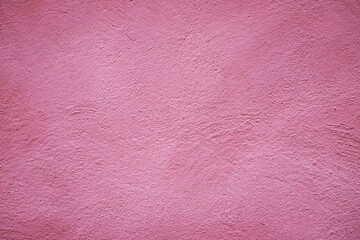 Fototapeta premium View of a textured pink wall showing small uneven patterns and a smooth surface in natural light during the day