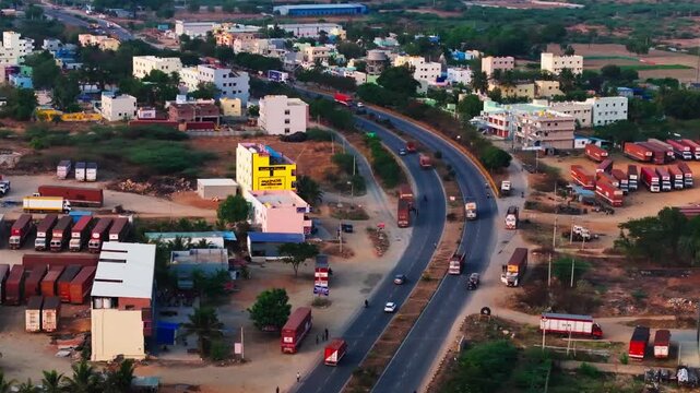 Vehicles moving on NH44 with AH43 and buildings at Gutturu, andhra pradesh, india. day time, stable shot, drone shot, 4k.